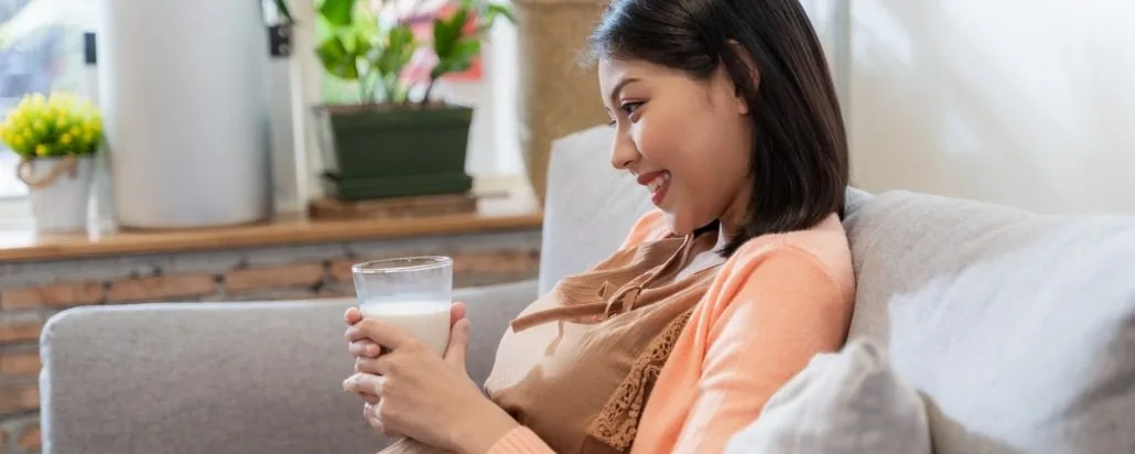Ibu nyusoni bayi sinambi ngasta cangkir unjukan
