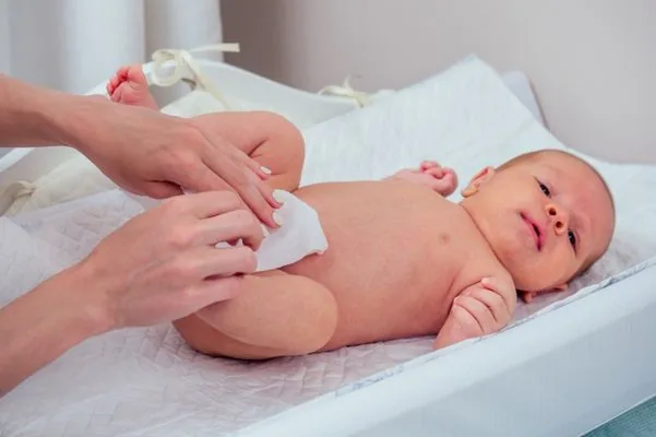 Mama sedang Membersihkan Tubuh Bayi Menggunakan Tisu Basah