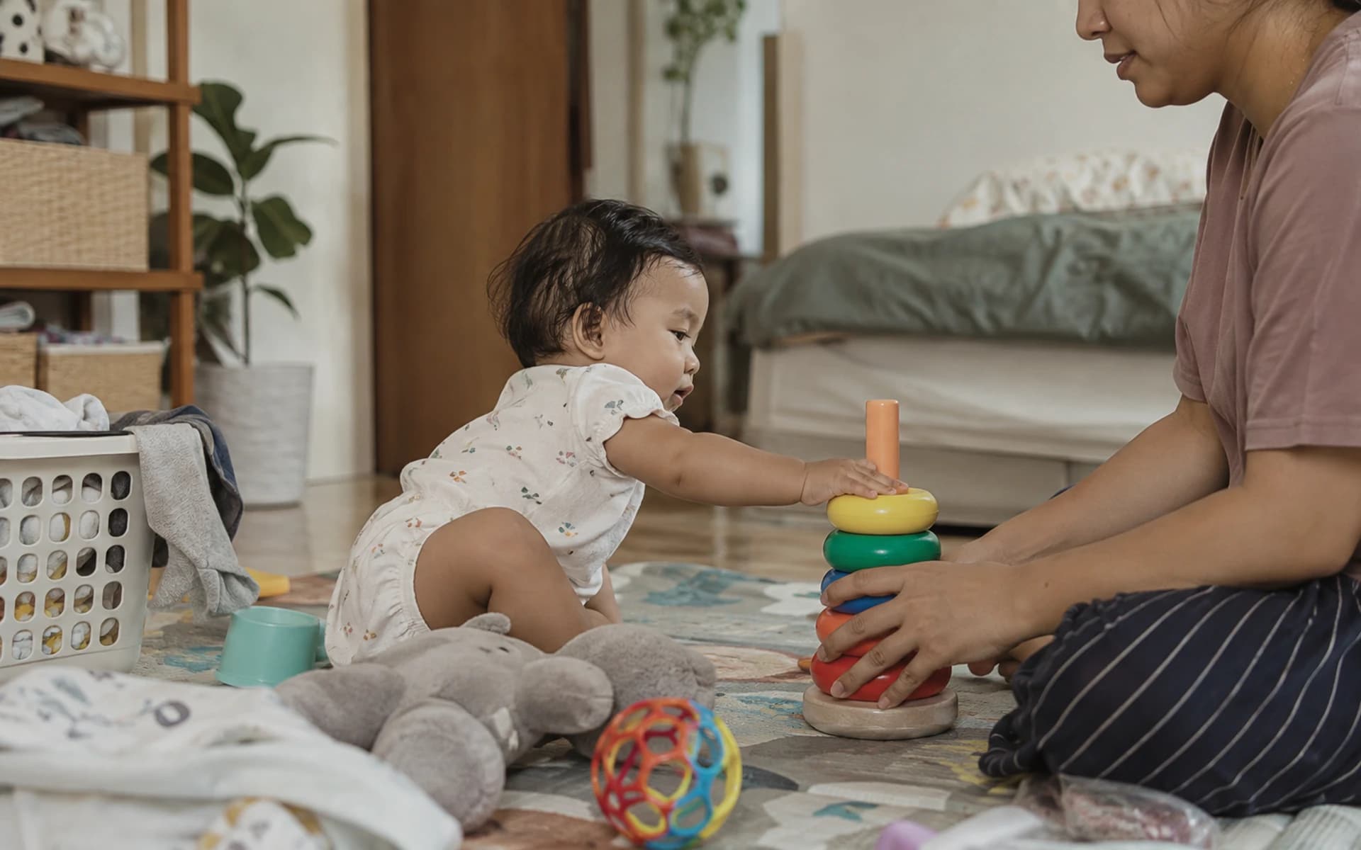 Bayi bermain di lantai bersama orang tuanya di rumah