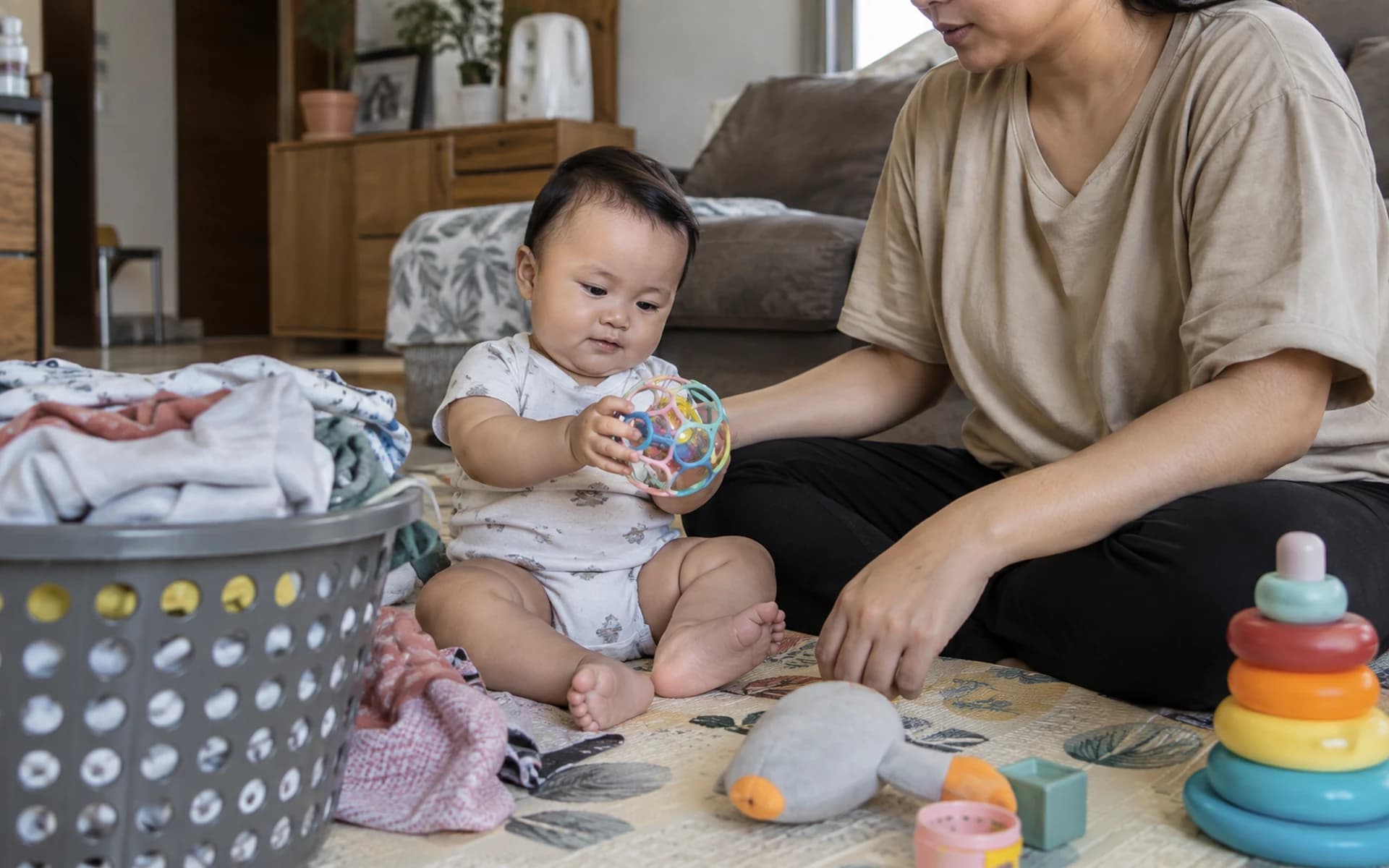 Bayi bermain di lantai bersama orang tuanya di rumah