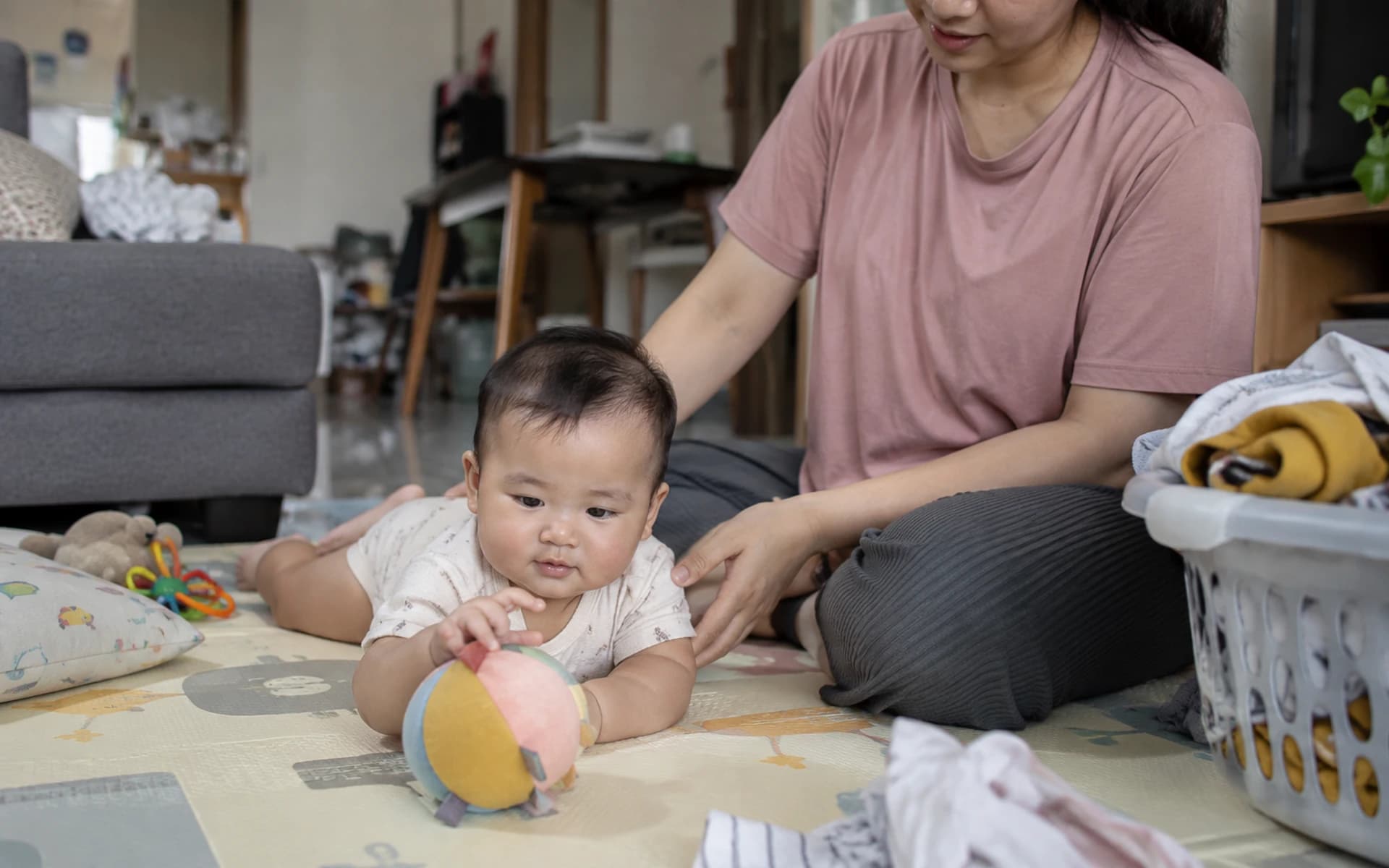 Bayi bermain di lantai bersama orang tuanya di rumah