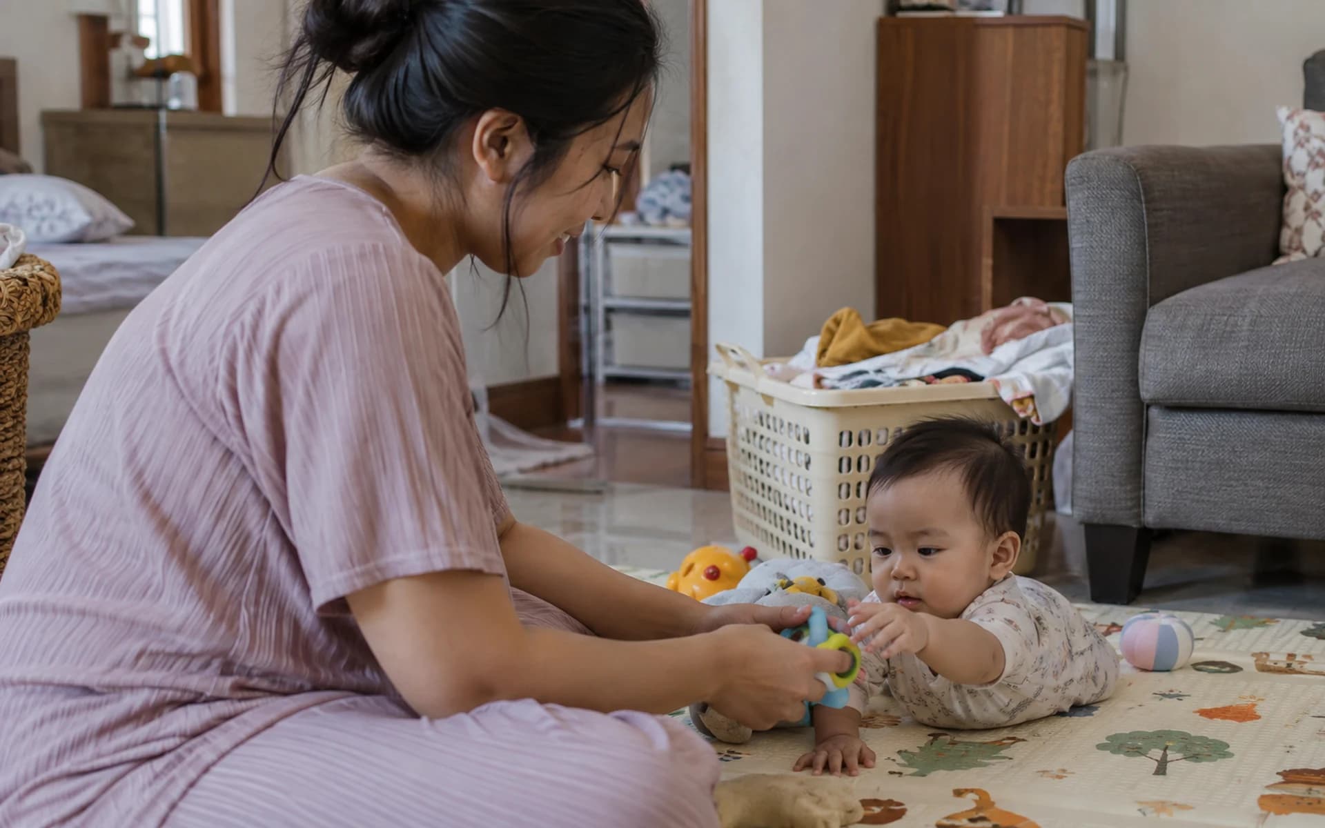 Bayi bermain di lantai bersama orang tuanya di rumah